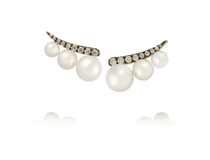 These handmade 18-karat gold earrings have graduated white pearls that seemingly float along the bottom of your ear. The 0.21 carats of sparkling diamonds are contrasted by blackened settings. 