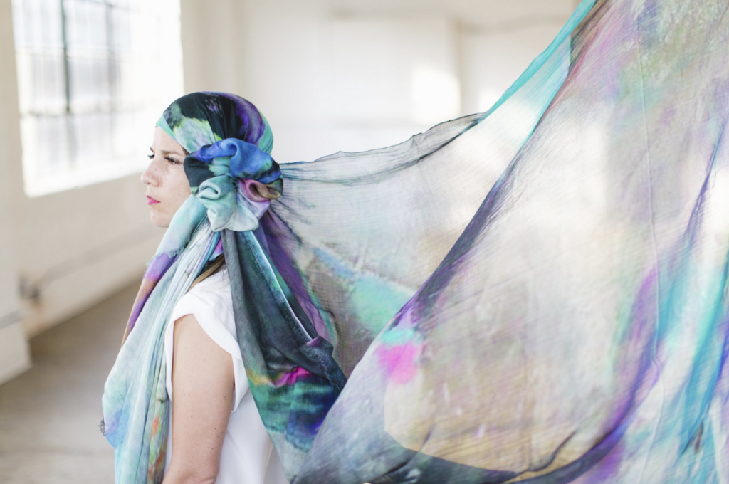 Megan Silianoff models the Susan Scarf, which features a painting by Houston-based artist Marilyn Byles. 