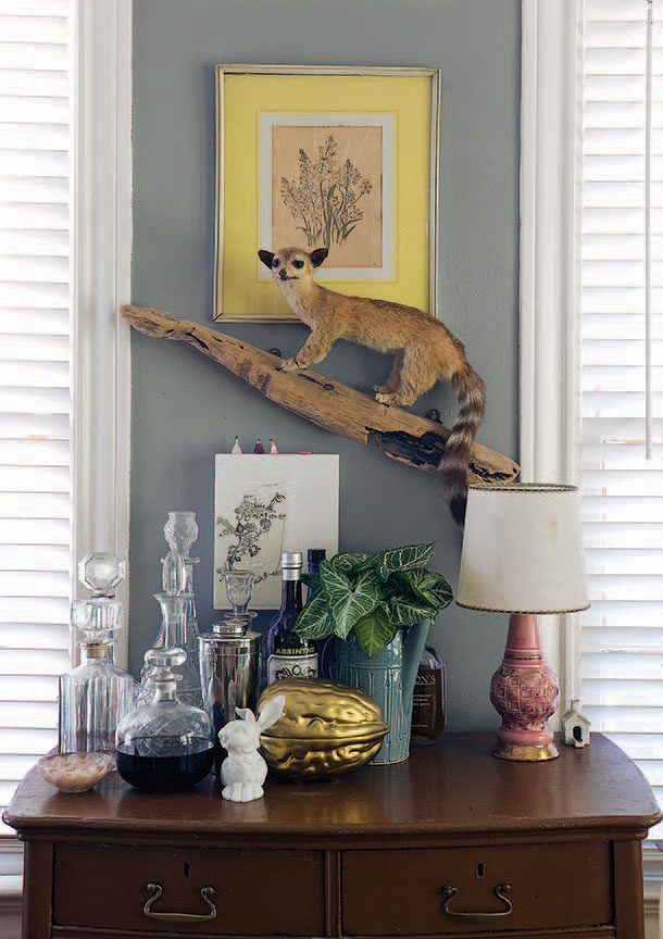 Vintage taxidermy ring-tailed lemur, one of many such pieces in the house. Vintage barware. Mixed-media collage by Chad Landry. Vintage lamp from The Guild Shop.