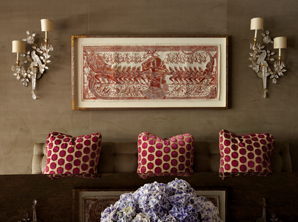 In the dining room, framed antique temple rubbing is from Angkor Wat temple in Cambodia. The Baguès sconces over the custom banquette are part of a rare set of four.