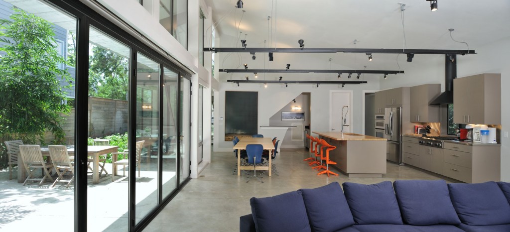 The interior of the Upper Kirby space by Scott Ballard LLC includes a large, open living space integrated with natural light. 