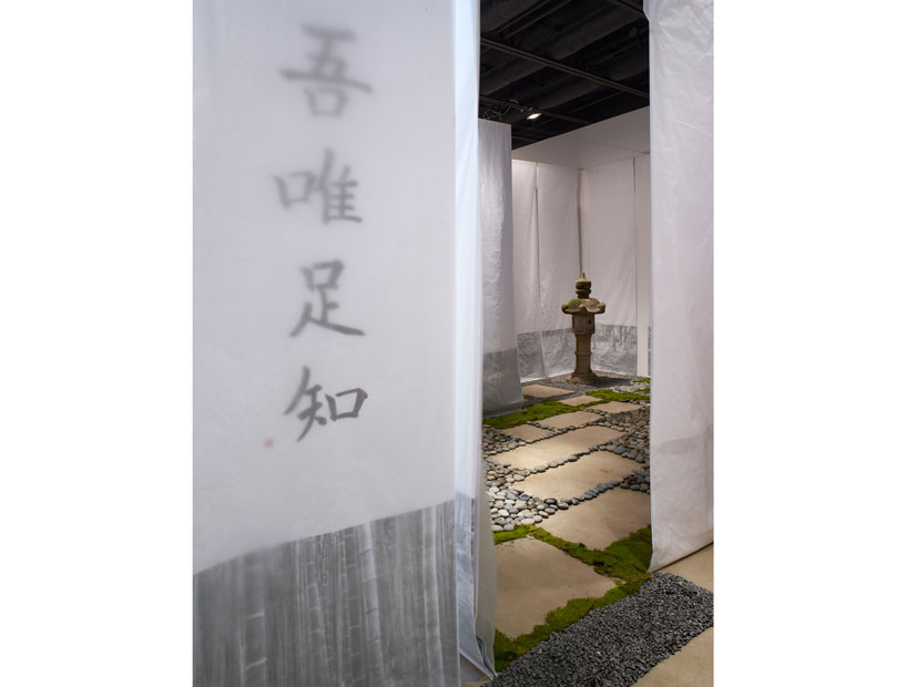 Calligraphy upon fabric scrims, rocks, moss, stepping stones, and a single garden ornament mark the entrance to "I Am Content with What I Lack."