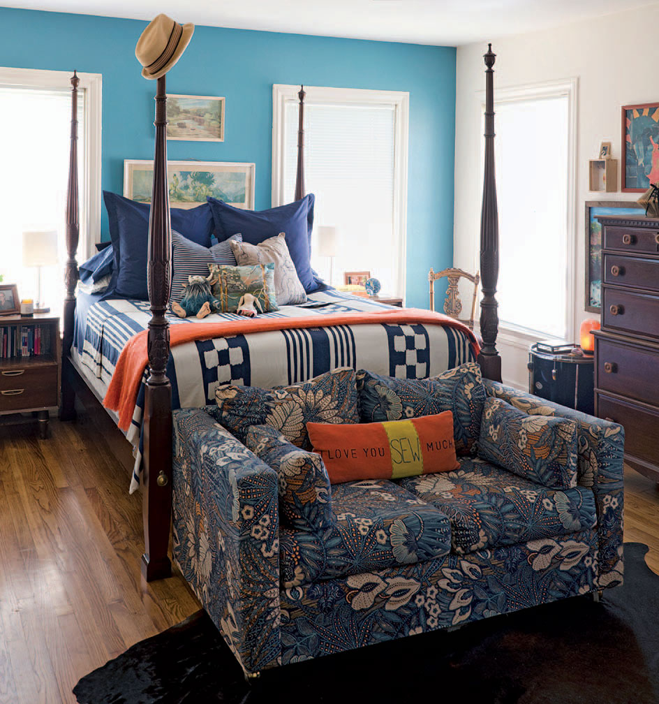 The master bedroom is painted Green Key by Ralph Lauren. Above the bed hangs the National
Geographic print Discovery, inherited from Scott’s grandparents. Antique Queen Anne poster
bed. Duvet from Urban Outfi tters. Pillows from IKEA and Ralph Lauren. The retro loveseat was
scored at a local Goodwill store. Handmade pillow by Sensabaugh and Scott.