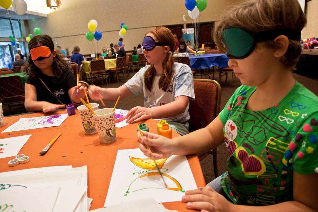 Achievement Center of Texas shows Kids Give kids how to paint without sight.