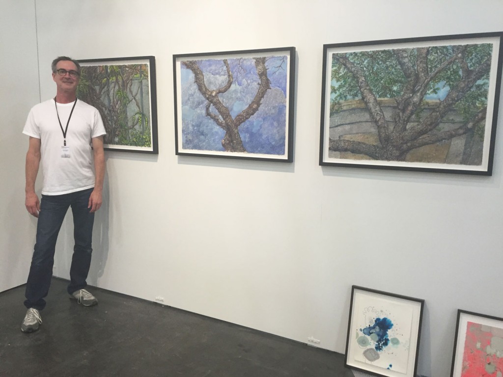 Inman Gallery goes with a conceptual landscape theme. Director Patrick Reynolds poses with a wall of Beth Secor paintings.