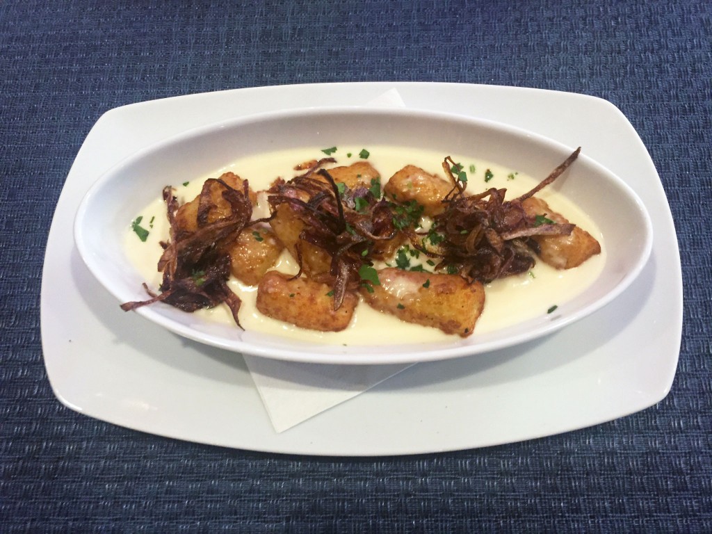 The Del's gnocchi tots are served in a cheddar and ale fondue, then topped with fried onions. 