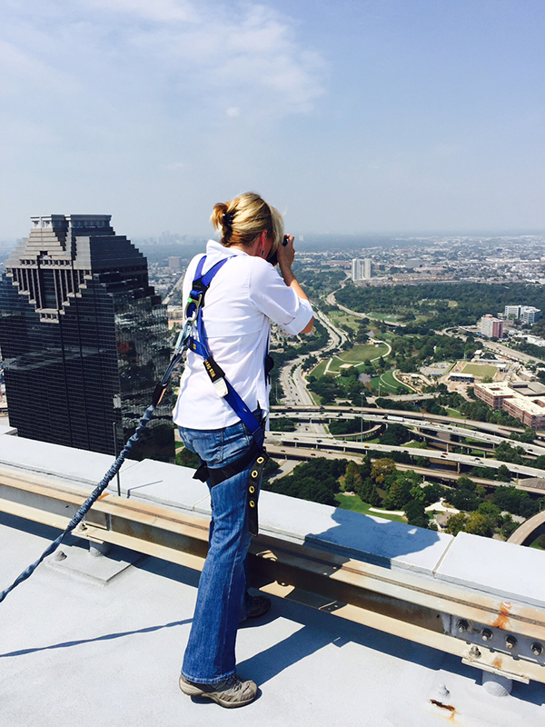 Strapped in for safety, Moen goes to work taking images off the roof of One Shell Plaza. (Note the safety harness.) 