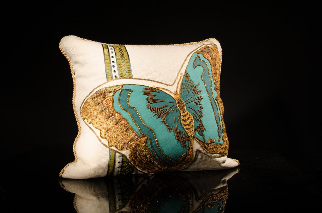 Hand-beaded turquoise and green butterfly, appliqued onto linen; trimmed with gold braid, metal antique ribbon and vintage deco glass beads; cream silk back with hand-beaded insect and vintage French ribbons, $2,200