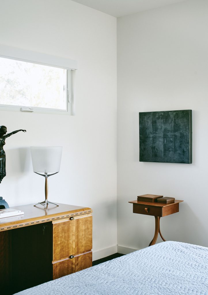 In the guest bedroom, the ribbon-edge desk was designed by Wayne Braun in figured cherry and in lay for HBF (Hickory Business Furniture). Shaker-style table and Artemide lamp, both vintage. Untitled work by Nick Terry. 