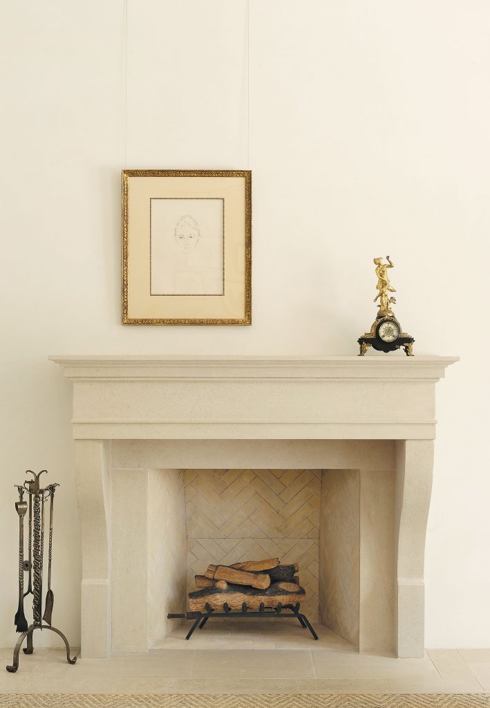 The living-room mantel is sparely installed with two treasures: a pencil-signed and numbered lithograph of Frau Dr. Linder by one of Lauren’s favorite artists, Edvard Munch, and an antique rococo clock
inherited from her grandmother. The antique pewter fi replace tools were purchased in New York.