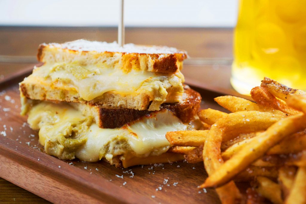 TGP's grilled cheese utlizes jalapeño cheddar bread, muenster and American cheese, and green chile gravy. 