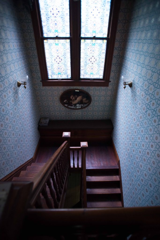 The stairwell woodwork is original. Hand-painted walls. Richard Bettinger art piece in antique frame.