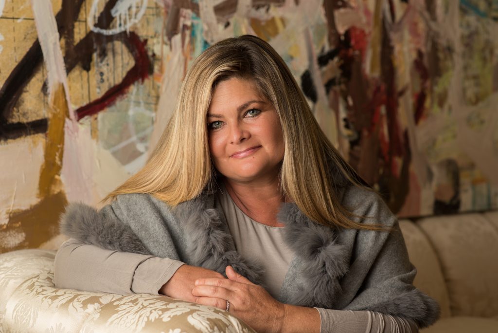 Jacquelyn Herold at home in front of Galen Cheney's "Pressing the Flesh," mixed media on canvas, 2015. (Photo Brooke Fletcher)