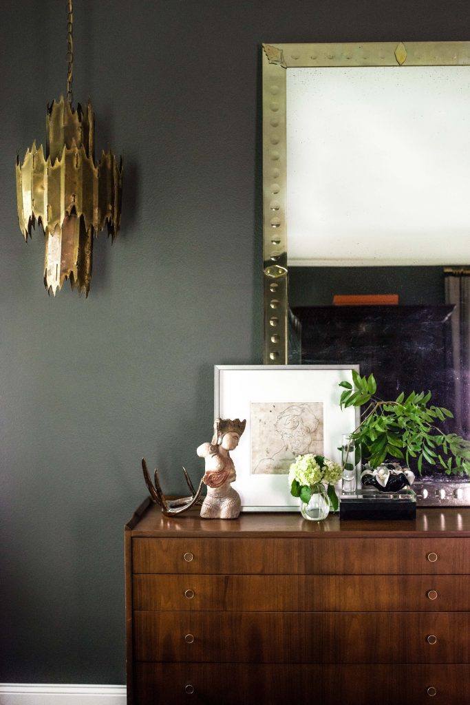 In the master bedroom, one of a pair of brass
Brutalist pendants
sourced by Steve Shuck from White Elephant. Mid-century chest from Antiques Moderne. Mirror from Wisteria.