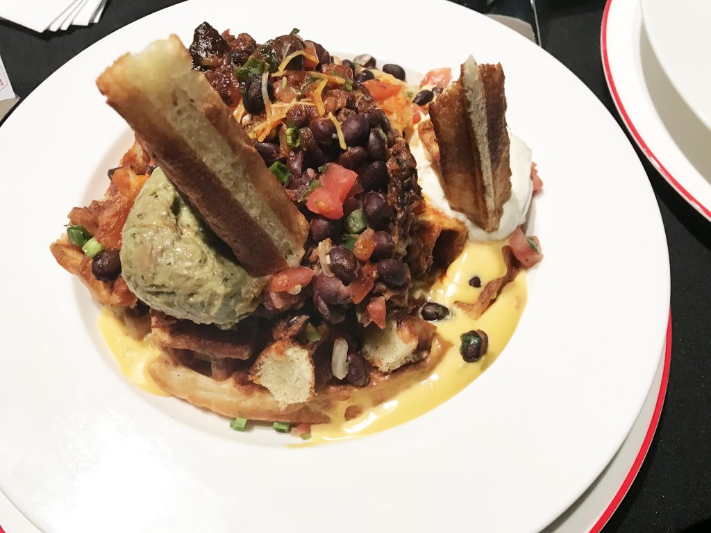 Crunch waffles are topped with smoked brisket or bbq pork, nacho beer cheese, and Korean bbq sauce to create the over time waffle nachos. 