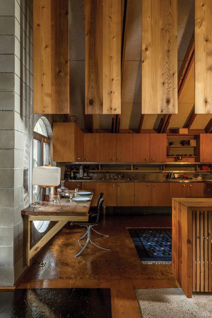 Built-in dining table in the kitchen, designed by the late architect, bears an Isamu Noguchi lamp. Chairs in black leather by Danish designer Poul Kjaerholm.