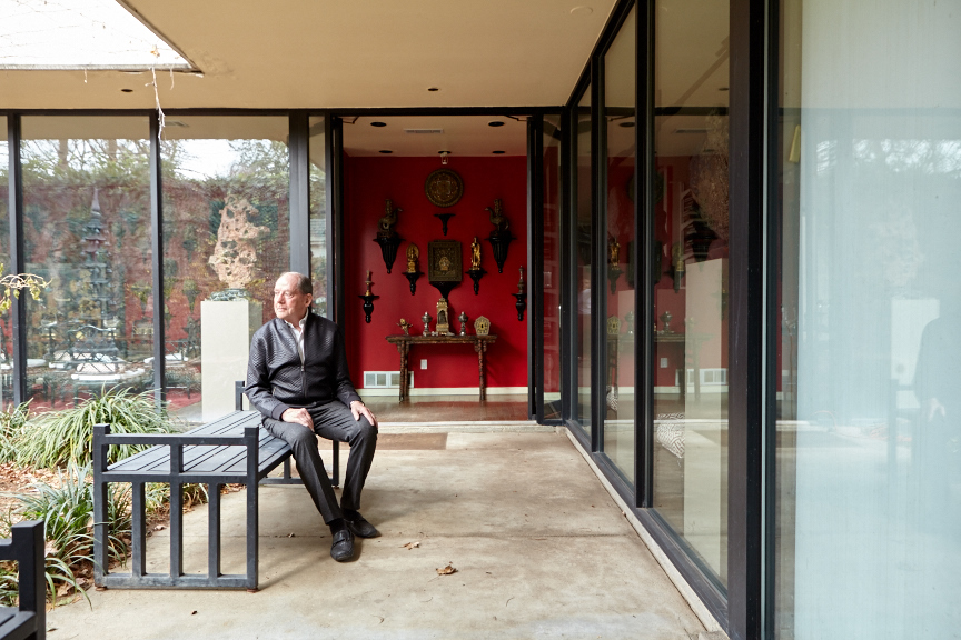 Loyd Taylor in the front courtyard. In the entry, objects from Tibet and India surround a Ming Dynasty wine table.
