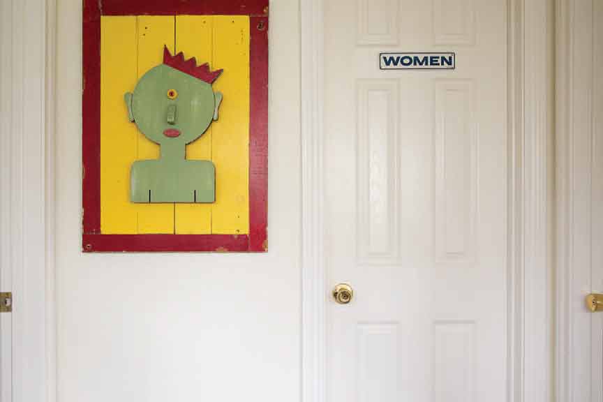 While primarily a sculptor, Prince occasionally conveys his message via two-dimensional creations. To the left of the women's room (the plaque a sign of the artist's sly humor). "In the Land of the Bind, the One-Eyed Man in King," 1997. 