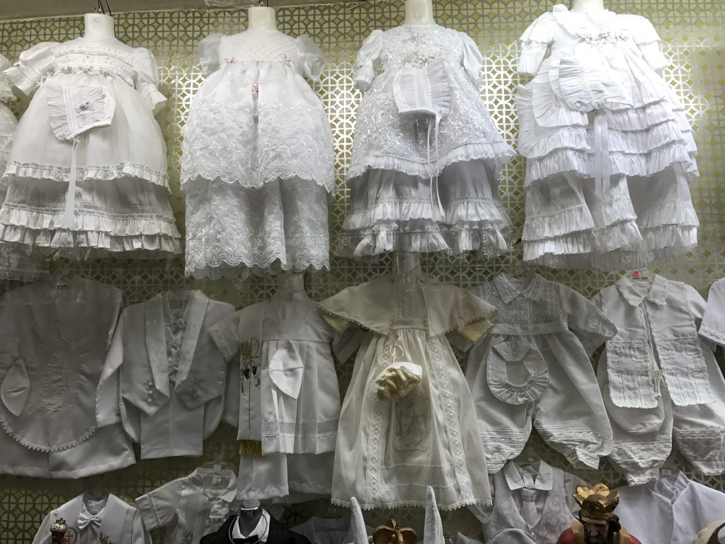 In Nuevo Laredo, a delectable shop window on overload with christening dresses.