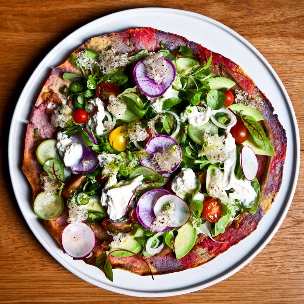 Tlayuda, black garbanzo, stracciatella, avocado, and chicharrón at Cosme 