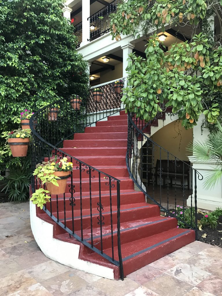 La Posada's vine laden courtyard features a staircase to the pool.