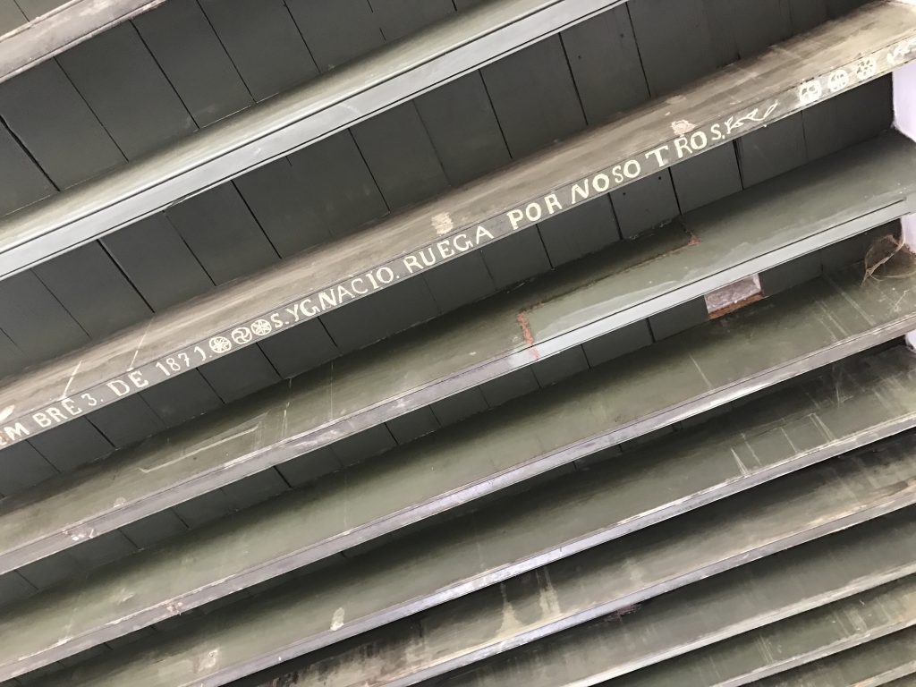 Cypress beams hold decorative inscriptions and dates of construction.