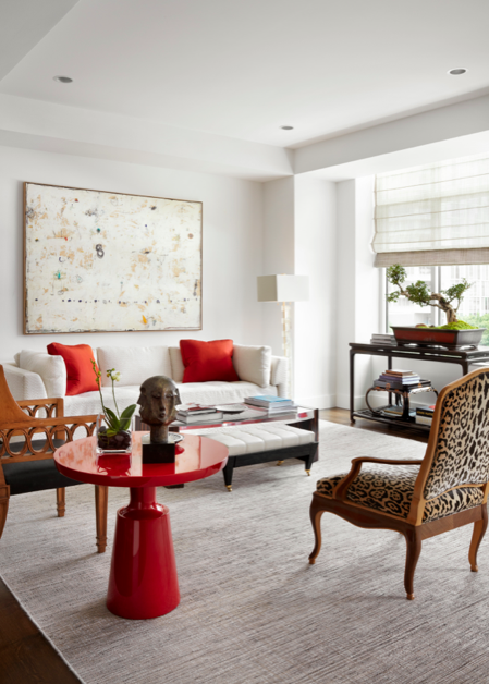 In the living room, a Cameron sofa upholstered in David Gibson fabric with Hermès pillows, and a Cameron table and bench, from George Cameron Nash. Holly Hunt lacquer table. Rose Tarlow Melrose House prototype chair. Yale R. Burge prototype chair upholstered in Clarence House leopard velvet. Antique Chinese console holds a 75-year-old Fukien Tea bonsai. Painting by Belgian artist Cole Morgan.