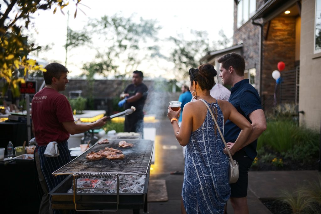 Guests admiring the featured chefs' culinary skills at Rhythm in the Heights 