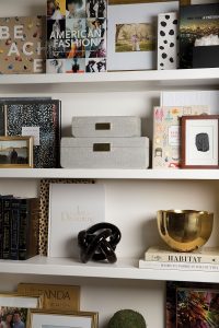 Designers Sarah and Saba Jawda styled the bookshelves, typically following a raid of Longoria Collection for coffee-table books and Aerin shagreen accessories.