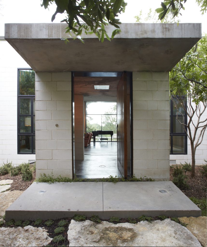 As in a Palladian villa, the house has a main entry from the south with an uninterrupted view to the north. James Ferrara’s design includes a cantilevered concrete roof, a low vestibule with skylight, commercial storefront windows, and solid oak door.