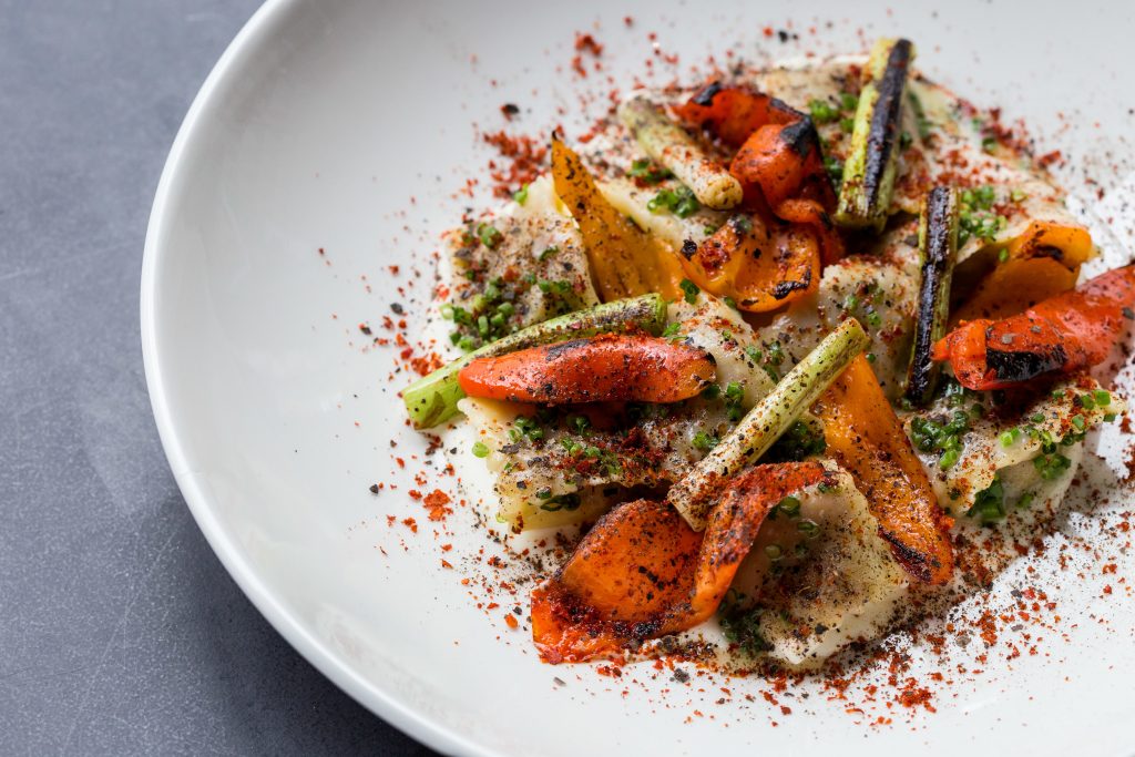 Heirloom beans salad topped with feta, pine nuts, pea shoots, and roasted peppers