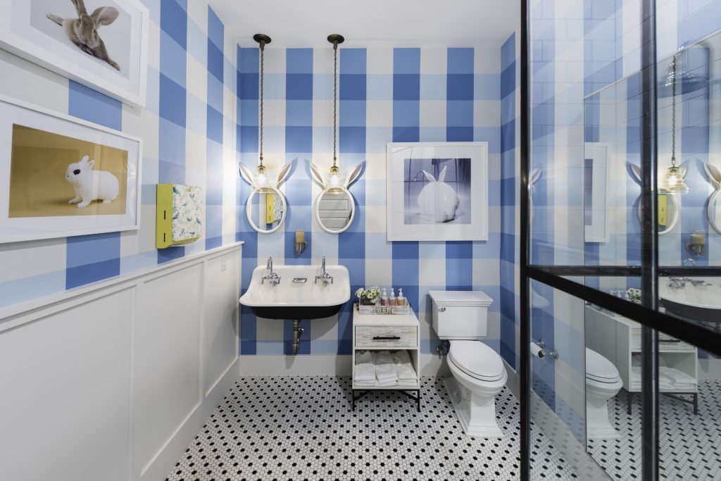 In one office bathroom, custom hand painted gingham walls by Peggy Jones; Wesley pendant lights by Arteriors Home; Land of Nod Good Hare Day wall mirrors; Custom shower by GlassHouse Dallas; West Elm cabinet; Kohler Broadway cast iron sink. (Photo by Manny Rodriguez)