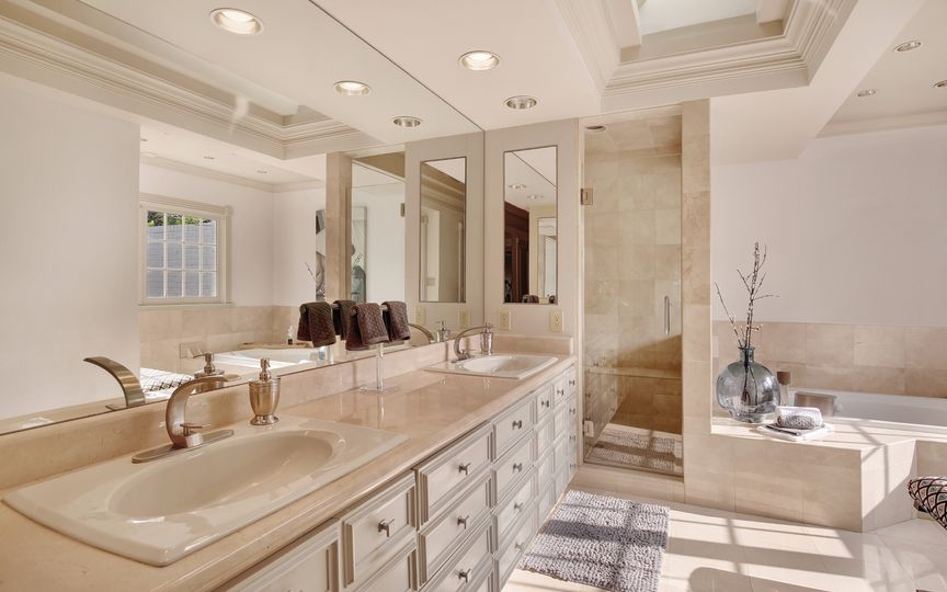 The master bath features double vanities, a separate shower, and a jetted tub. 
