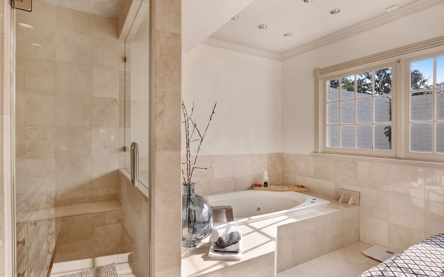 The master bath features double vanities, a separate shower, and a jetted tub. 