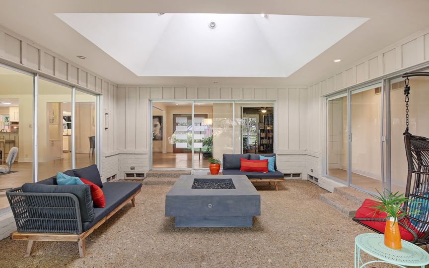 The unique covered atrium features a mod fire pit for year-round entertaining. 