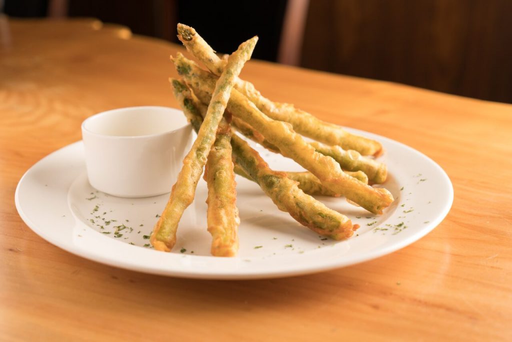 Tempura fried asparagus are served with a lemony aioli. 
