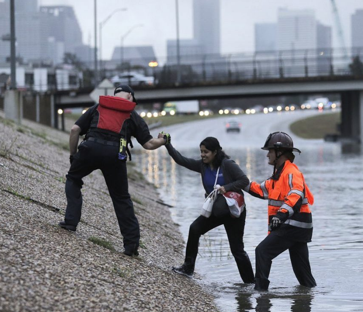 Woman rescued by first responders from flooding freeway.