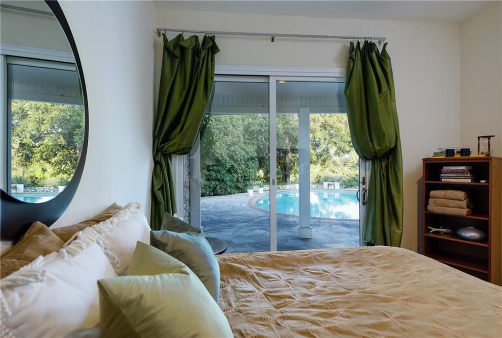 The rear of the home has floor-to-ceiling windows looking out on the pool and lake. 