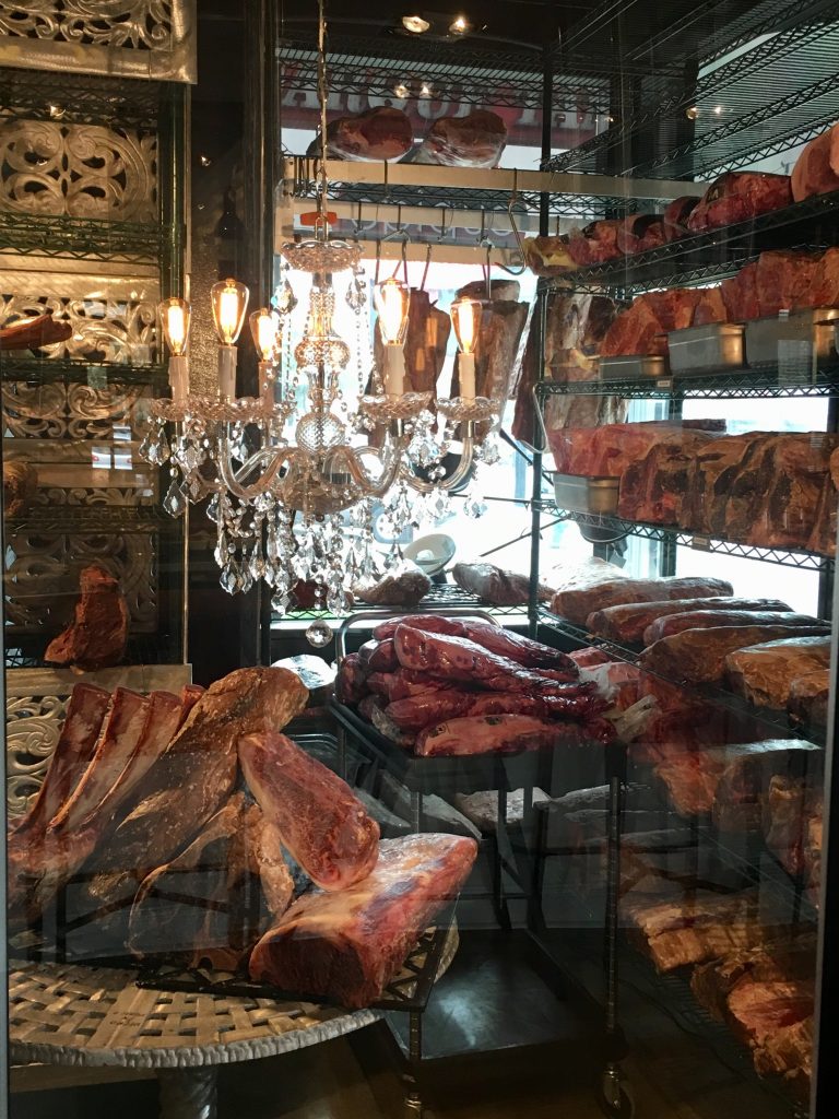 A crystal chandelier hangs above Japanese A5 Wagyu. (Photo by Annie Gallay.)