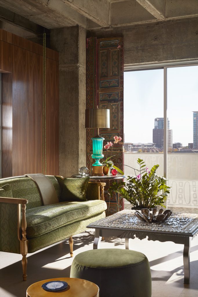 Hand-painted Moroccan doors, circa 1950, flank the glass. Turquoise glass lamp with brass shade, circa 1980. Linda Ridgway's Secular Rosary, 2002, hangs from the ceiling. 