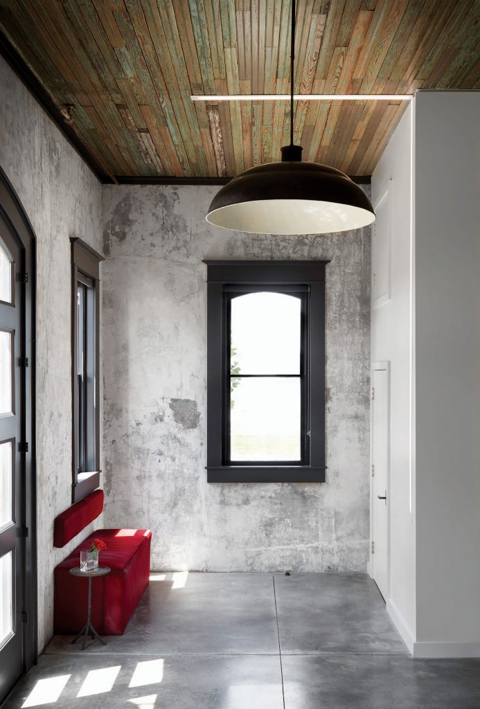 In the entry, original headboard ceilings and patinated plaster walls. Vintage light pendant, circa 1910. Custom bench. 