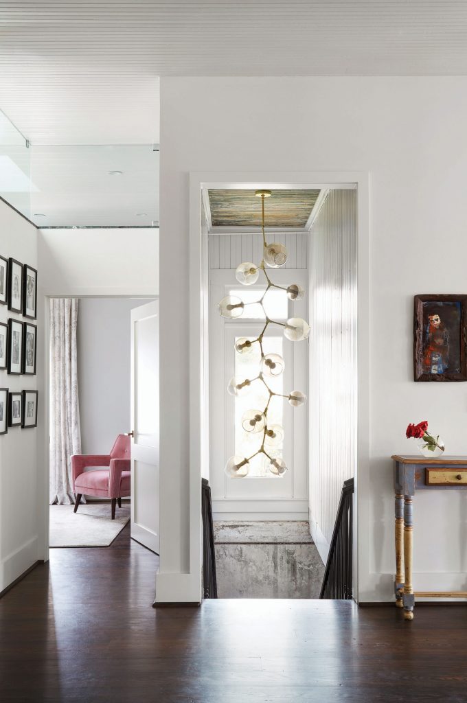 Brass-and-glass light fixture was handmade in L.A. Glass transom in the bedroom lets light into the hallway. Vintage chair with C&C Milano pink velvet. Painting from Guatemala. 