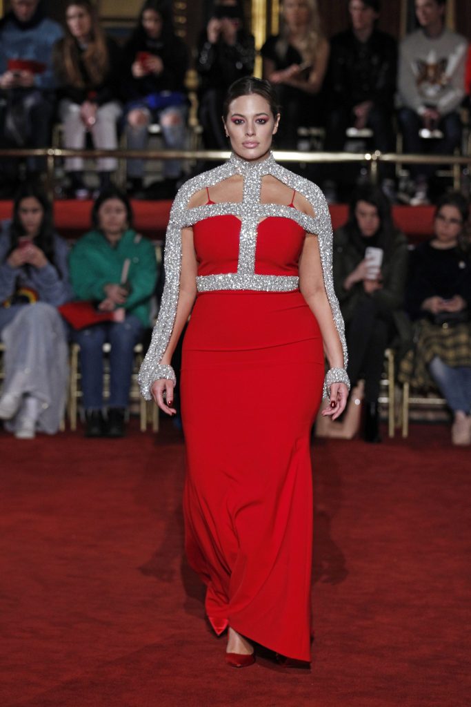 Ashley Graham models a Christian Siriano red textured crepe slip gown crystal cage collar.
