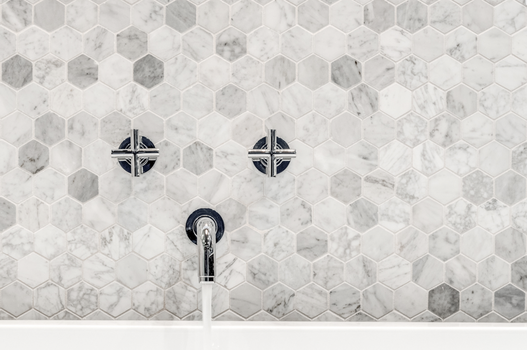 Marble hexagon tiles add flair to this Joseph & Berry remodeled master bathroom, complete with a standing steam shower that features a DTV operating system. 