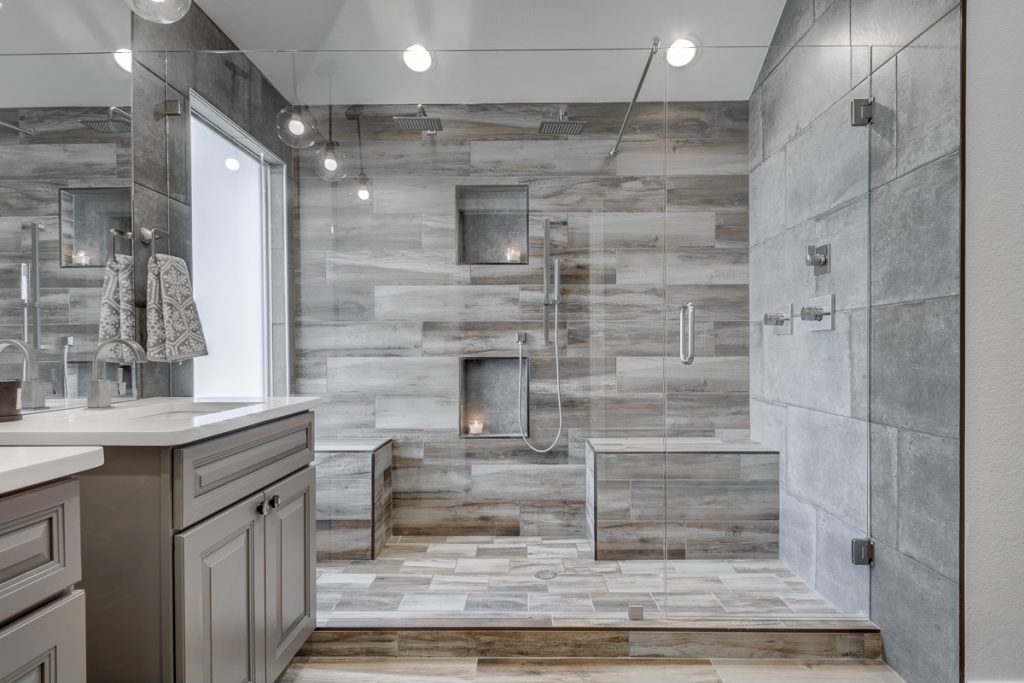 A window wall, brushed nickel accents and wood looking tiles, all in your master shower; what else can you ask for?