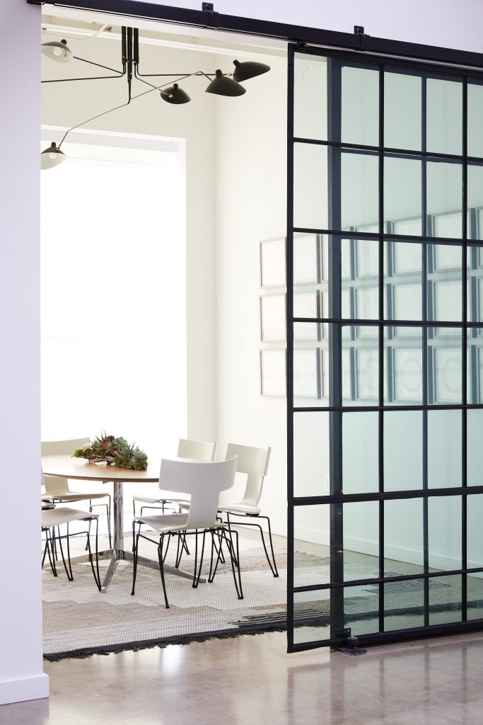 In the conference room, a vintage rosewood Knoll table surrounded by Klismos chairs by Donghia. Linnea Glatt’s Bow Tied. Rug from West Elm. 