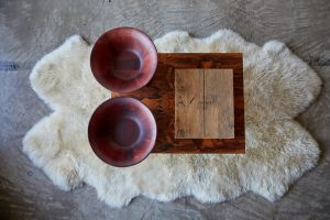 Vintage wood-veneer chrome table, wooden box holding "Visionaire 60 Religion Riccardo Tisci for Givenchy", and Michael Graves wood urns from JC Penney.