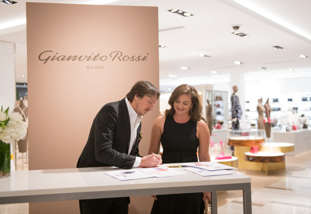 Gianvito Rossi signs a rendering of one of his shoes for Maritza Gonzales at his Saks Fifth Avenue  launch party.