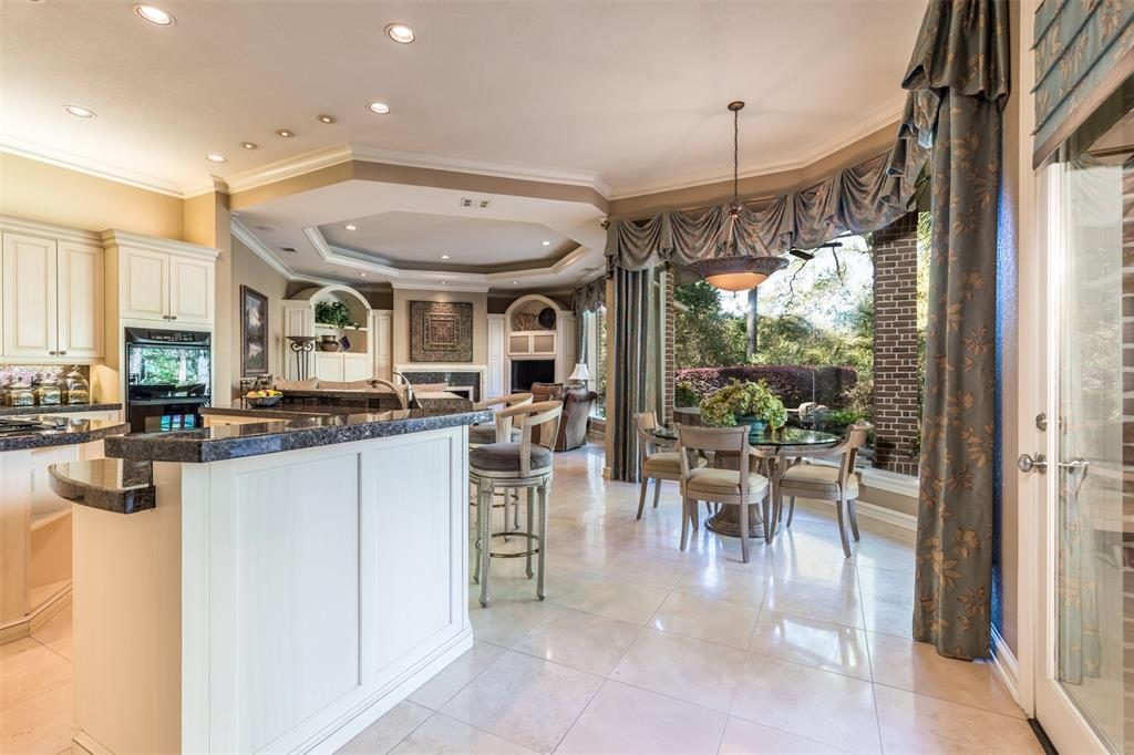 The family room is the perfect gathering place, with a raised bar in the kitchen and a breakfast area that overlooks the pool. 