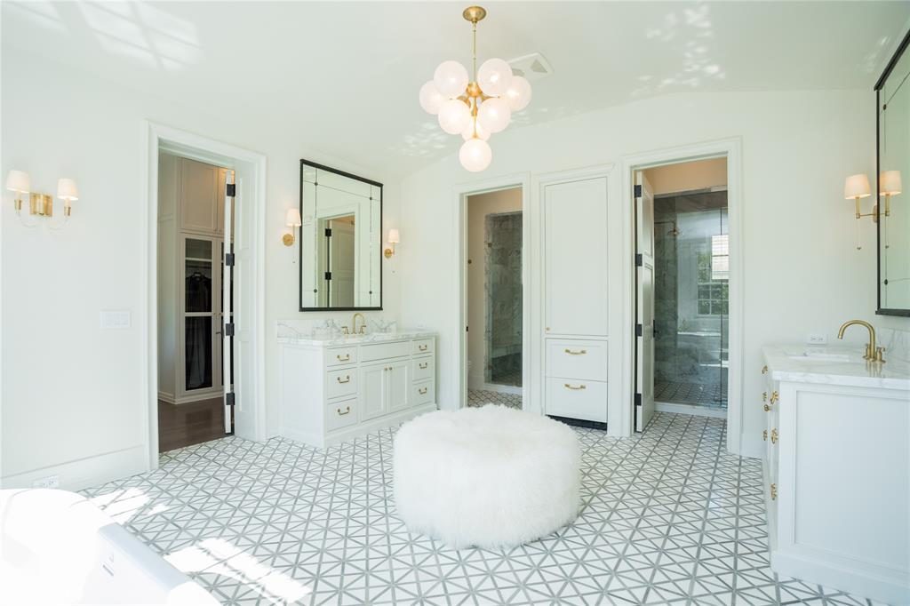 The master bathroom is a peaceful space with white and grey marble floors, and porcelain sinks. 